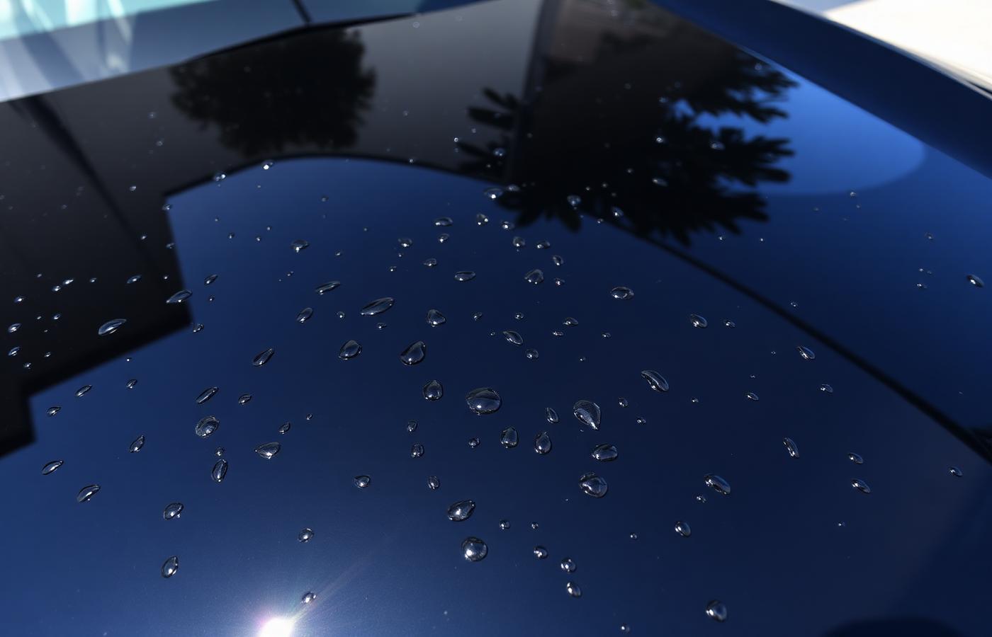 Water beading tightly on a freshly ceramic coated dark blue hood